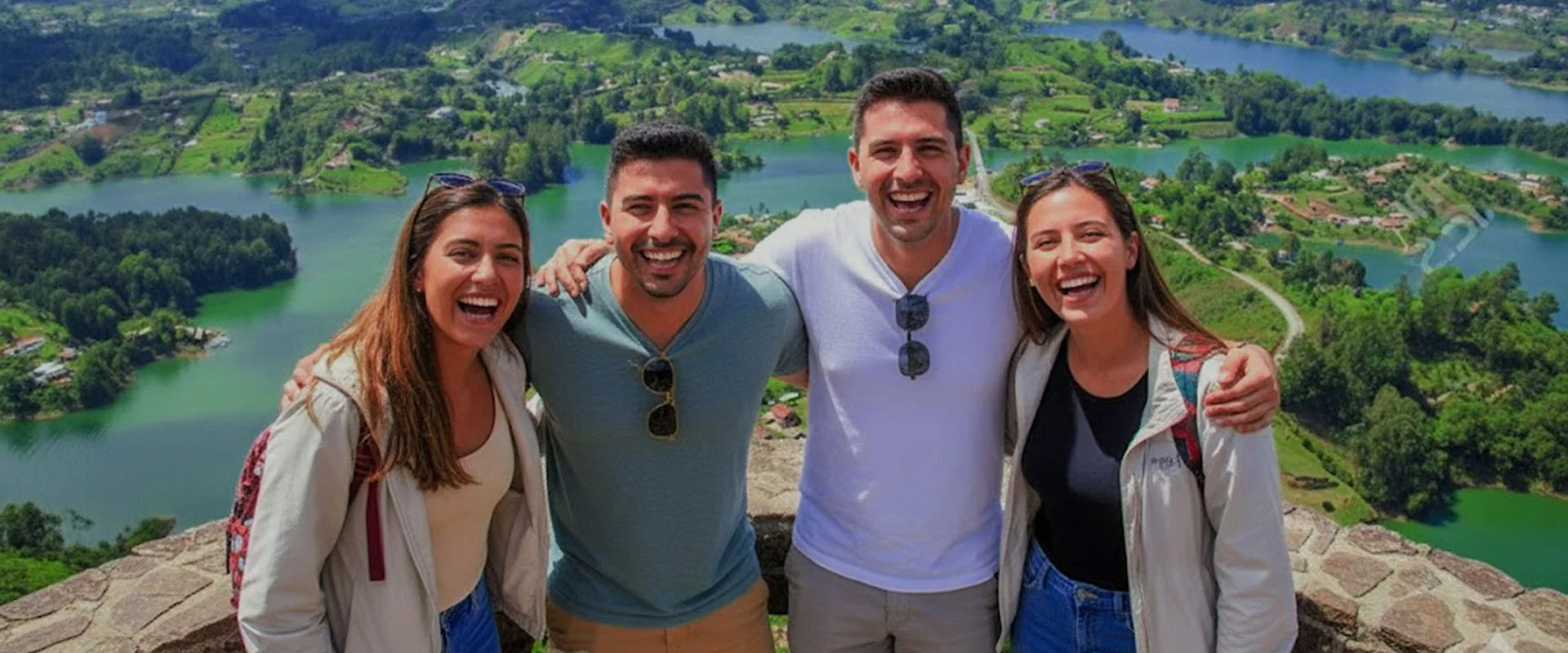 Turistas disfrutando la vista panorámica de la Represa de Guatapé. Parejas jóvenes en la cima del Peñol, durante un tour desde Medellín.